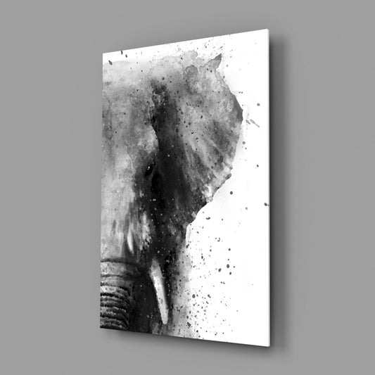 Black and white ink splatter elephant head on white glass panel, angled perspective view showing shadow against gray background.