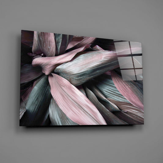 Close-up angled view of glass wall art displaying layered pink, teal, and gray leaf textures with motion blur effect.