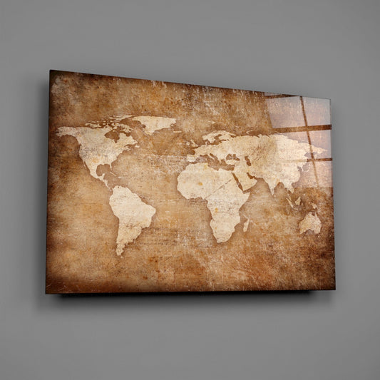 Angled view of rectangular glass wall art displaying a cream-colored world map on aged brown parchment background with visible shadow.