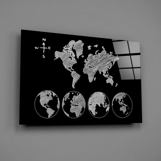 Black glass wall art featuring white sketched world map with compass rose and four globe views in circular frames, angled perspective view.
