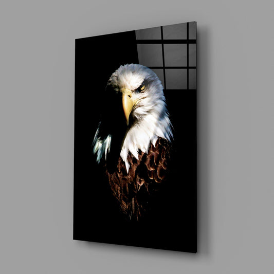 Angled view of glass wall art displaying a bald eagle's head against black background, mounted on gray wall.