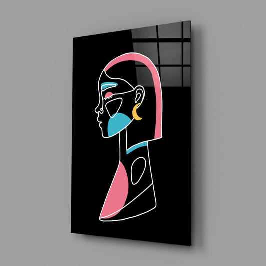 Angled perspective view of glass wall art displaying neon-style line drawing of profile face with pink hair, blue and yellow accents on black background.