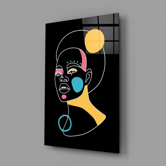 Glass wall art panel displaying abstract portrait with white outline, colorful geometric shapes in yellow, blue, and pink on black background, mounted at angle showing depth and shadow.