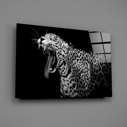 Black and white glass wall art featuring a yawning leopard with open mouth and spotted coat against dark background.