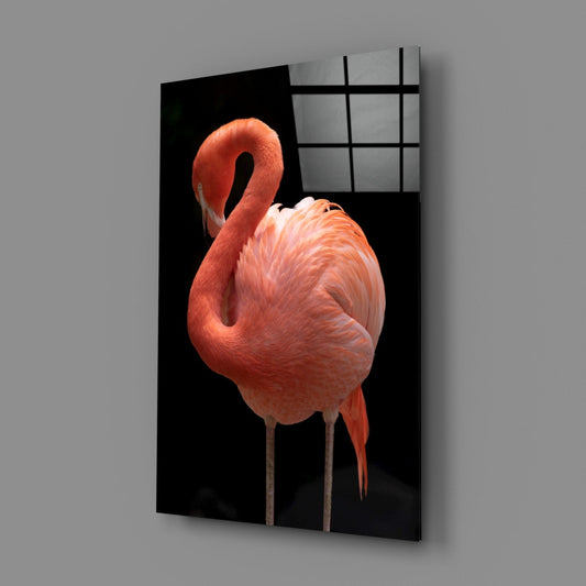 Angled display view of coral flamingo glass wall art mounted on gray wall, showing curved neck bird against black background with gridded window reflection.