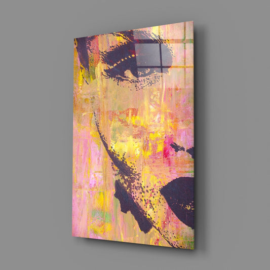 Angled three-quarter view of abstract face artwork on canvas showing pink, yellow, and black tones with textured brushstrokes and splatter effects.