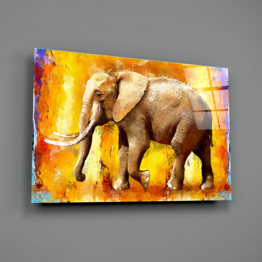 Glass wall art depicting a brown elephant with ivory tusks against a vibrant yellow and orange painted background.