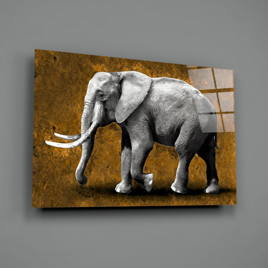 Detailed grayscale elephant with ivory tusks stands in profile against a textured golden-brown backdrop with rectangular design elements on glass wall art.