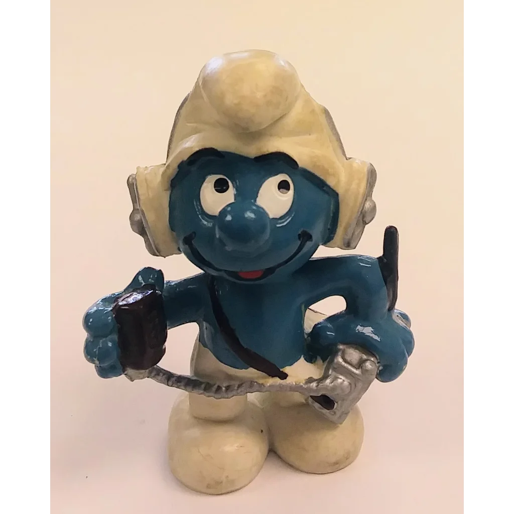 Operator Smurf figurine in white hat, blue body, holding microphone
