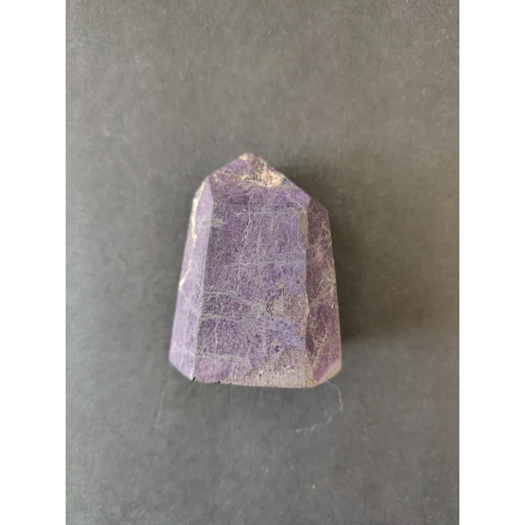 Faceted purple amethyst crystal in Purpurite Lapidary, rough texture, inclusions