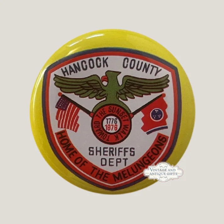 Yellow tin litho button pin: Hancock County Sheriffs Dept badge, eagle, crossed US and Tennessee flags, centennial 1776-1876 medallion.