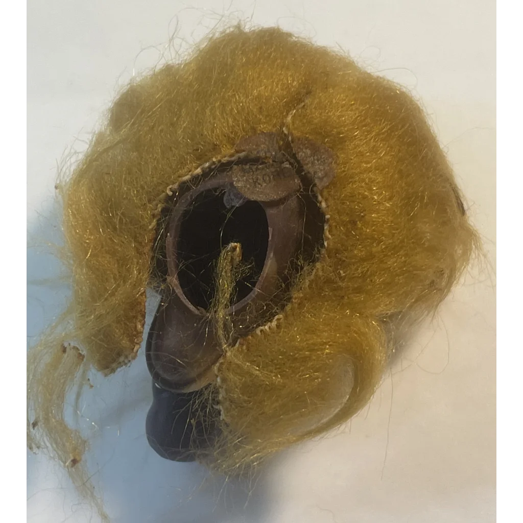 Partially eaten donut with yellow frosting next to a Vintage 1980s ALF Finger Puppet