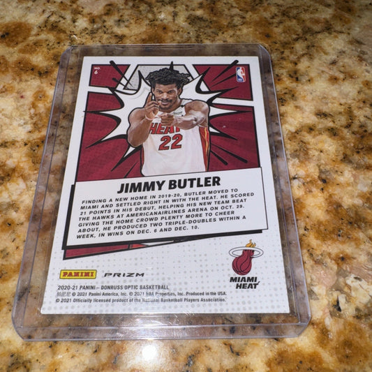 2020-21 Panini Donruss Optic Jimmy Butler card in plastic case on granite countertop, showing front with player photo and biographical text.