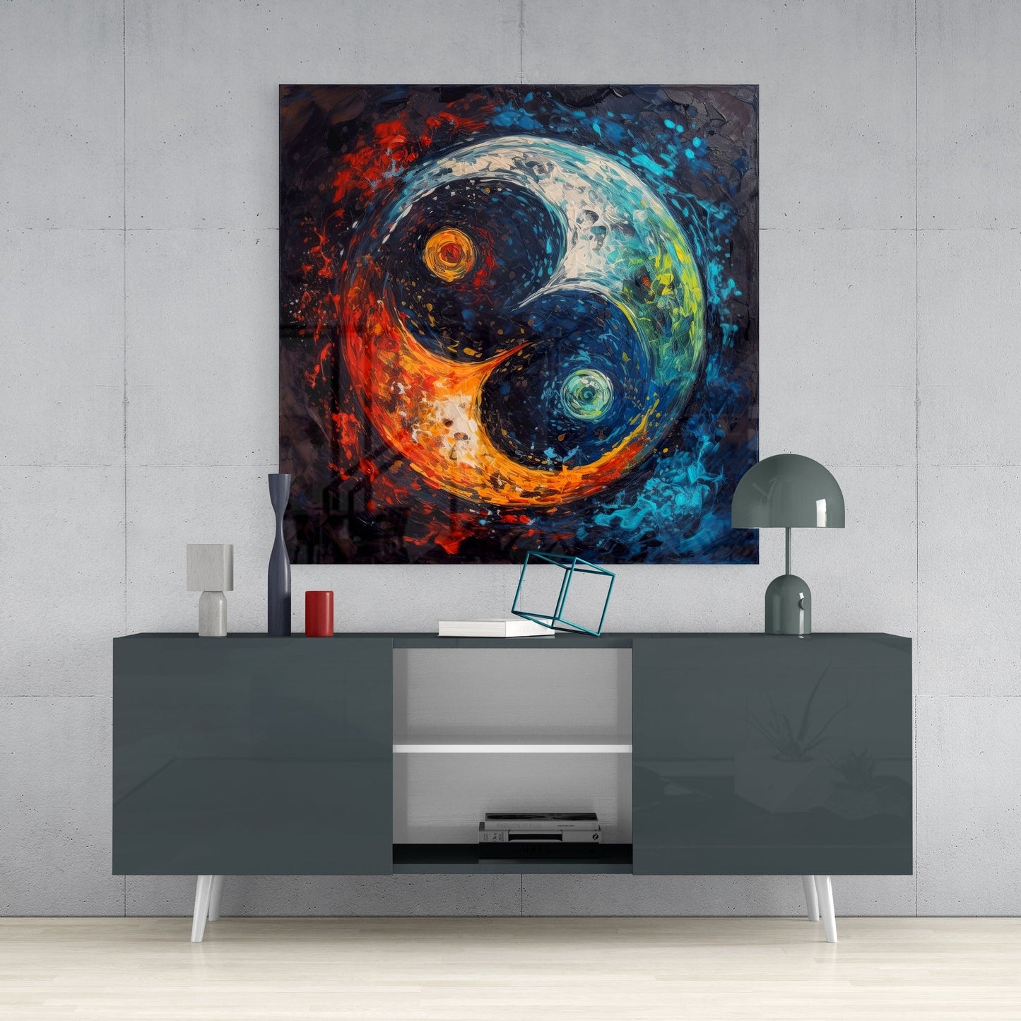 Yin and yang glass wall art with swirling fire orange and cool blue tones displayed above a modern gray media console in a minimalist interior setting.