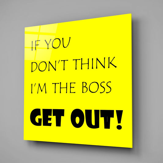 Yellow glass wall art panel with black text reading "IF YOU DON'T THINK I'M THE BOSS GET OUT!" displayed at an angle against gray background.