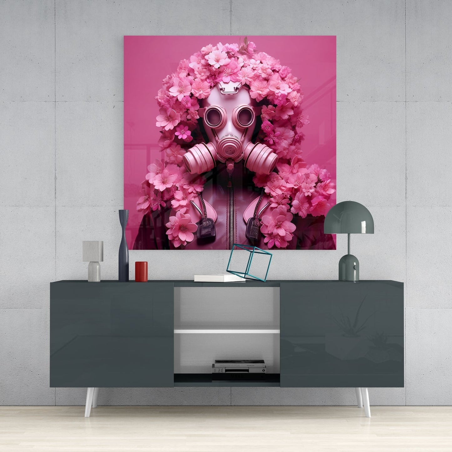 Pink glass wall art depicting a gas mask surrounded by pink flowers displayed above a dark gray media console in a modern interior setting.