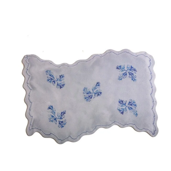 White acid flower table mat with scalloped edges and blue embroidery from Seletti Acid Flower