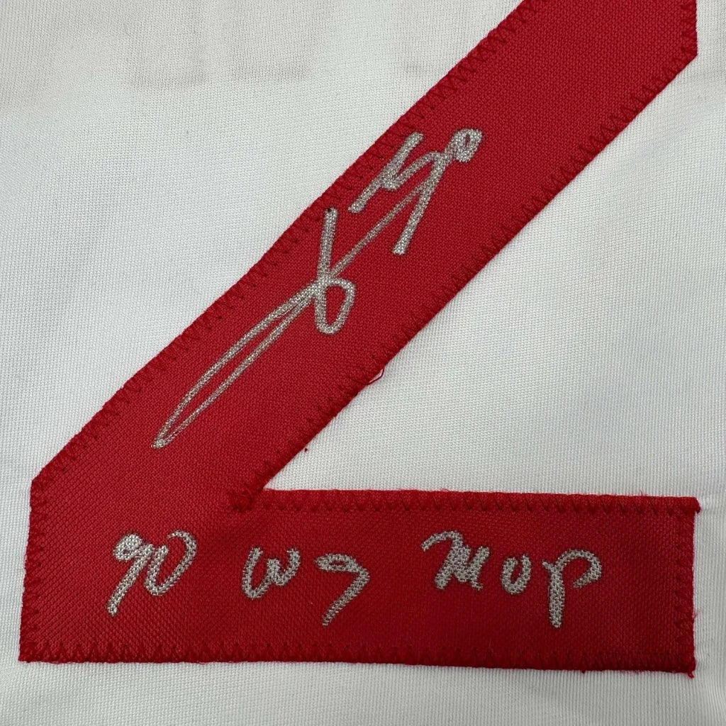 Signed red and white jersey with silver autograph, wall-ready display