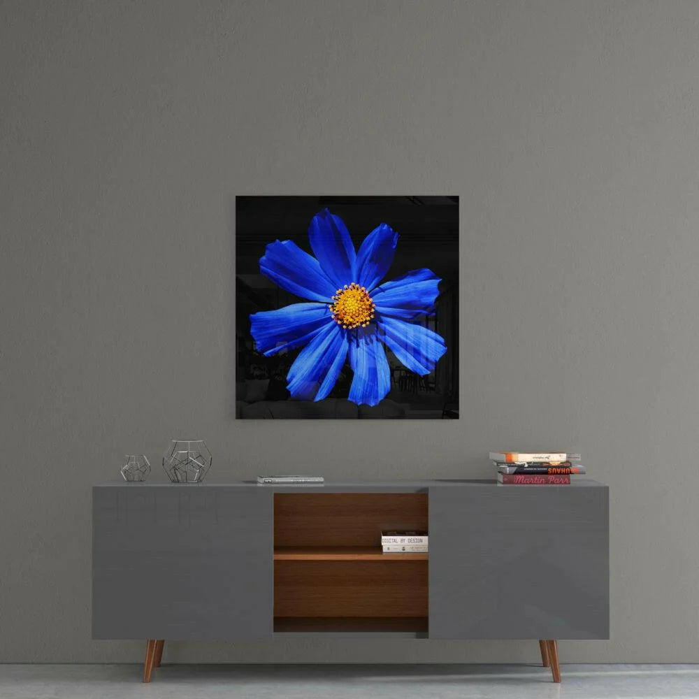Vibrant blue cosmos glass wall art with golden center on black background