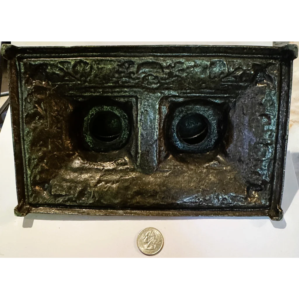 Dark ornate metal double inkwell desk accessory from late 19th century