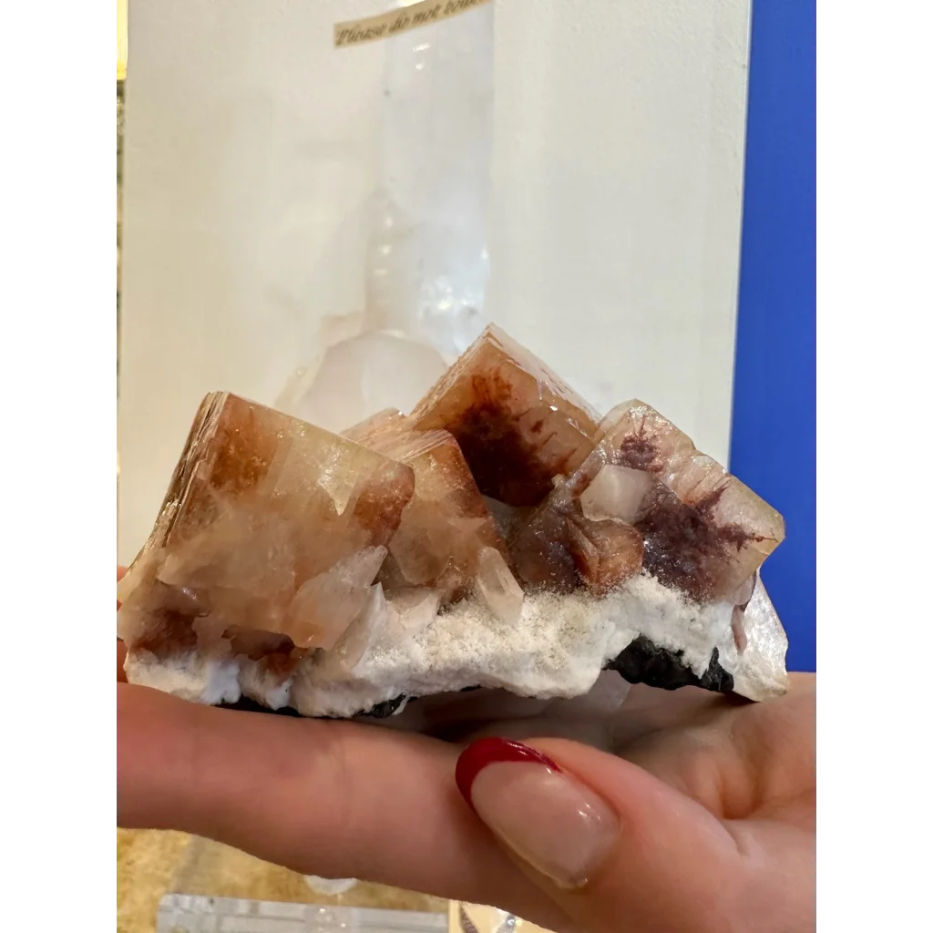 Hand holding stunning red apophyllite crystal cluster from Pune India