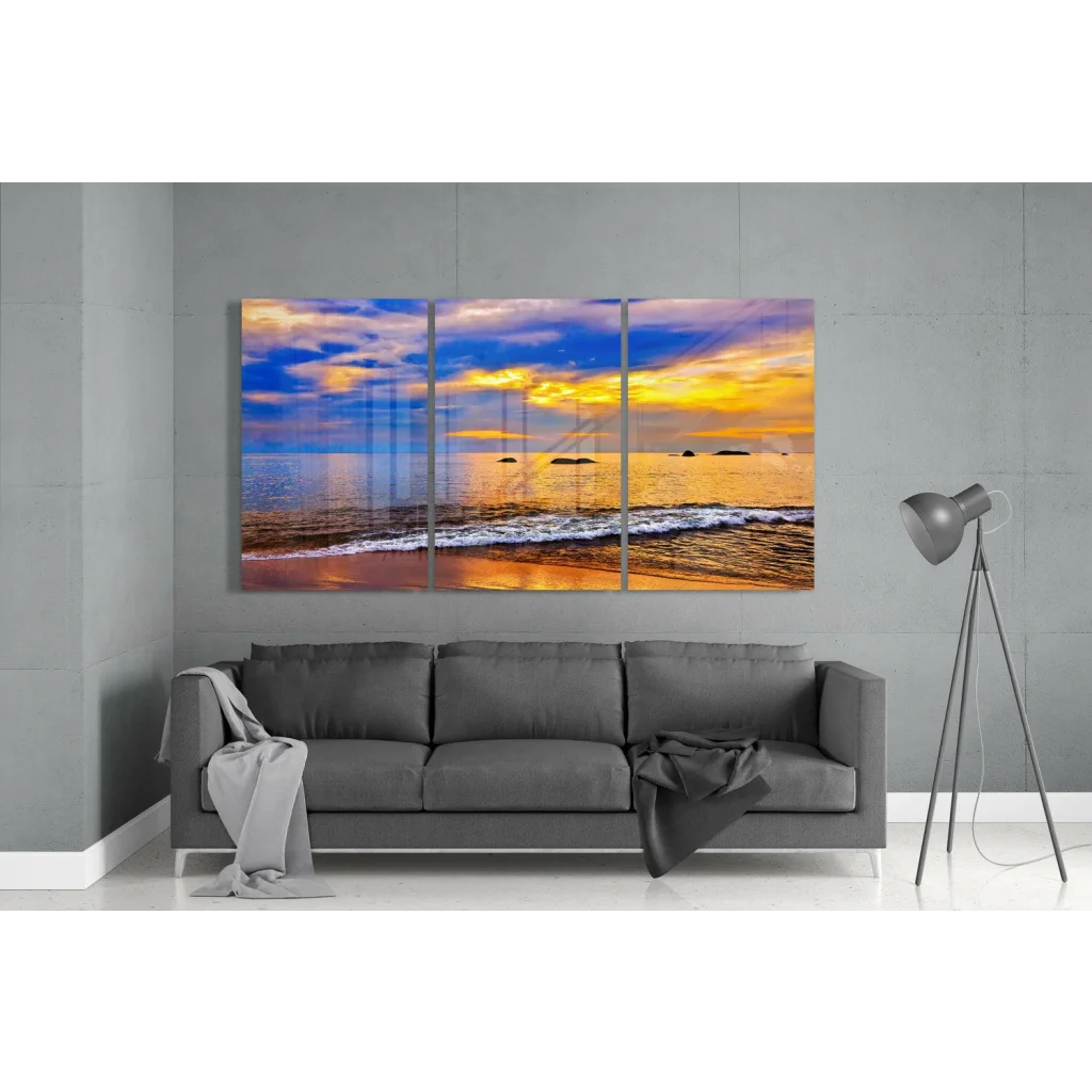 Vibrant tri-panel sunset beachscape glass wall art in golden blue hues
