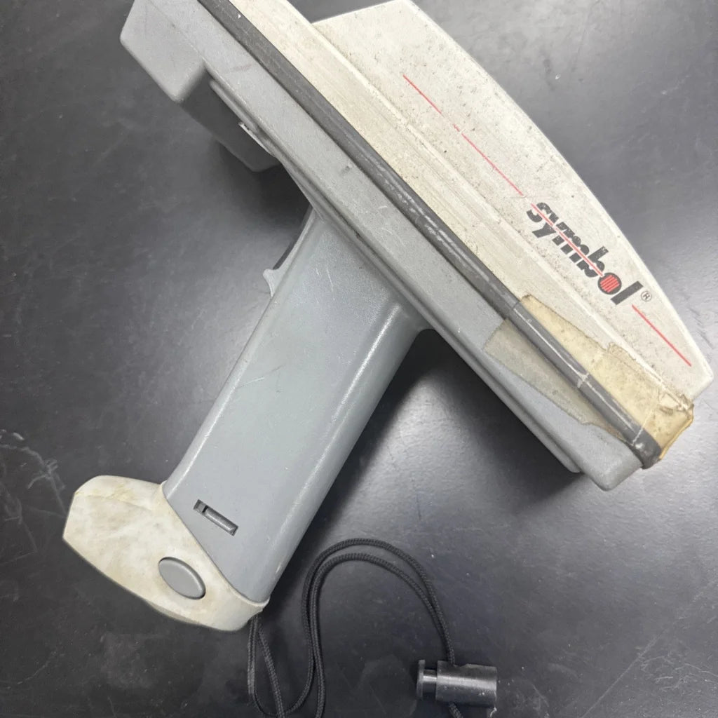 Worn gray Symbol barcode scanner with keyboard, dusty surface