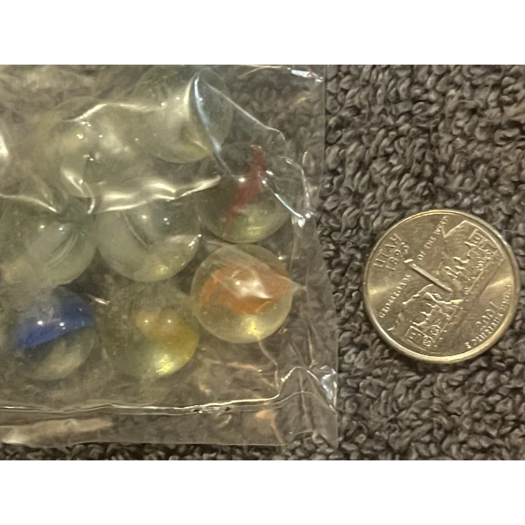 Plastic bag of vibrant Cats Eye marbles next to a coin for scale