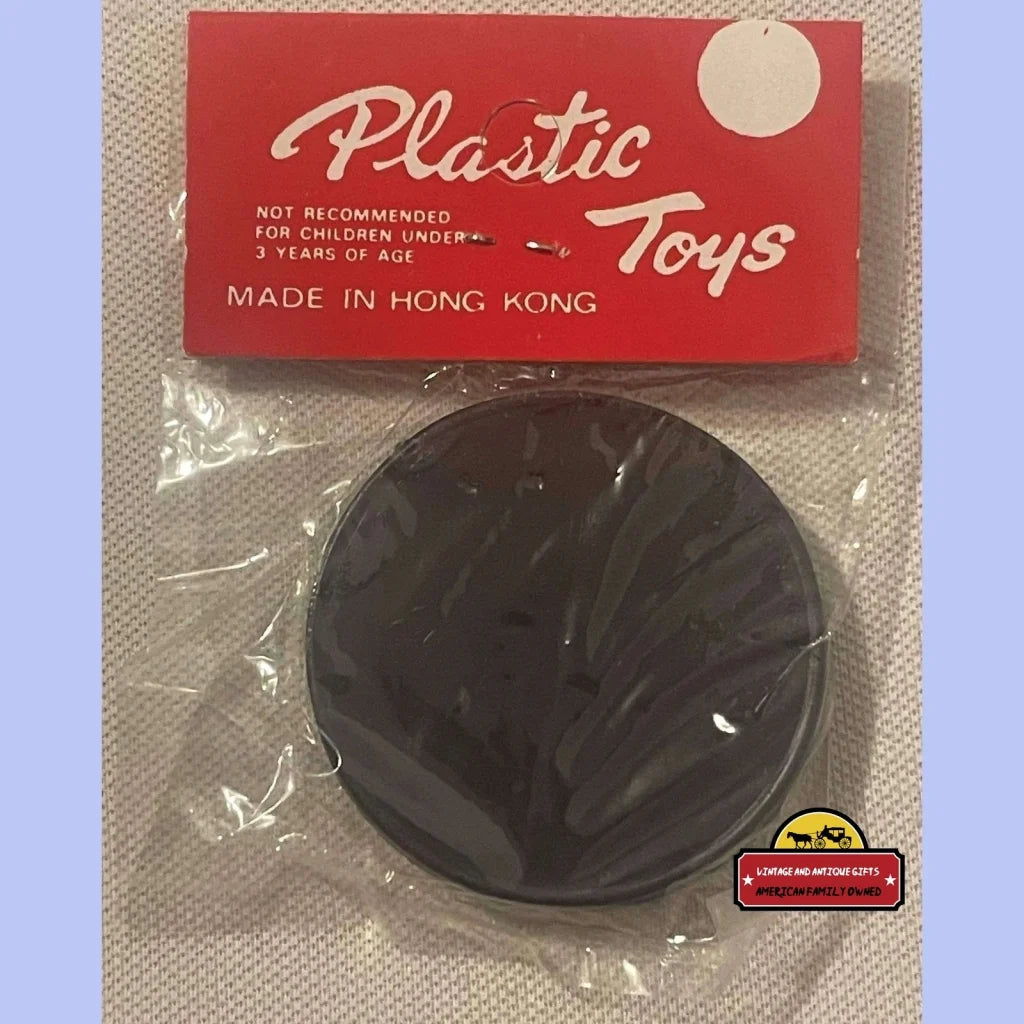 Black plastic disc toy in package for the 1950s Clown and Mouse toy puzzle game