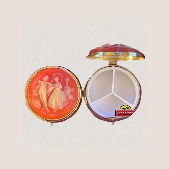 Vintage 1970s cameo pill box with dancing lovers featuring an orange-toned round compartment