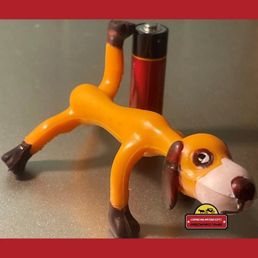 Elongated orange vintage bendable poseable dog toy with cartoonish face and limbs