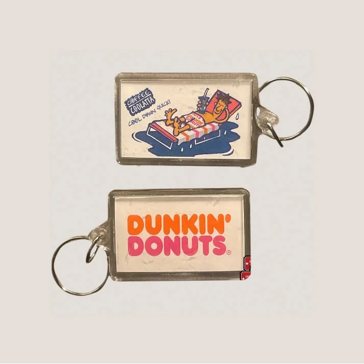 Two acrylic keychains: Coffee Coolatta cartoon character front, orange-pink "Dunkin' Donuts" logo back.