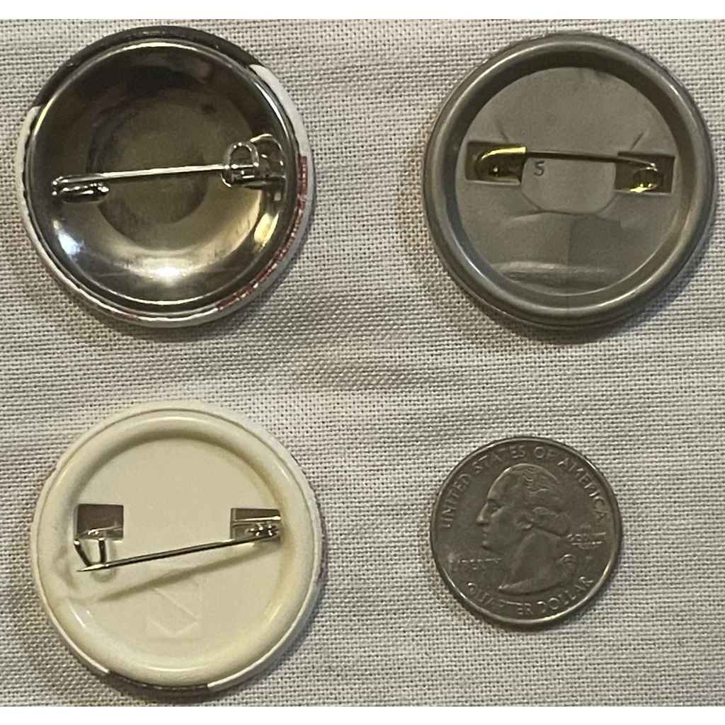 Button pin backs in various styles next to a coin, perfect for Mutant Ninja Turtles fans