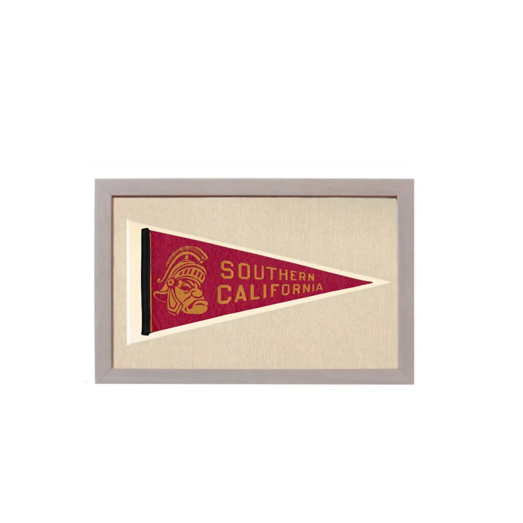 Vintage university of Southern California pennant in maroon and gold with a stitched Trojan helmet logo framed in light gray