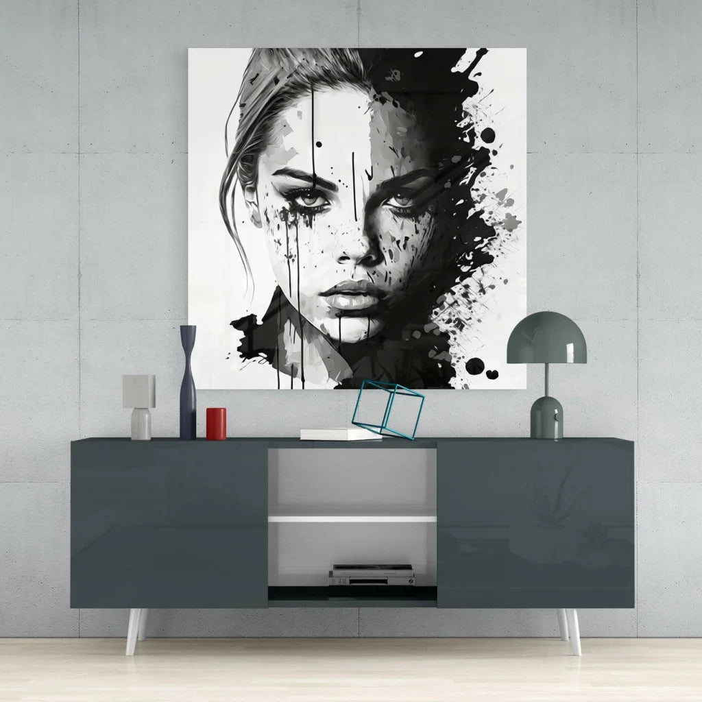 Black and white glass wall art portrait with bold ink splatters on a womans face