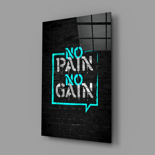 Angled view of glass wall art displaying turquoise neon-style frame with white graffiti text "NO PAIN NO GAIN" on black brick background.