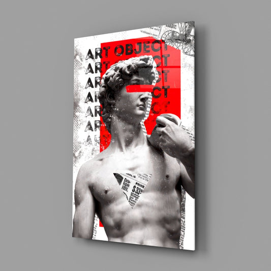 Angled view of glass wall art featuring classical marble bust with red geometric blocks, repeated "ART OBJECT" text, and newspaper clippings on white background.
