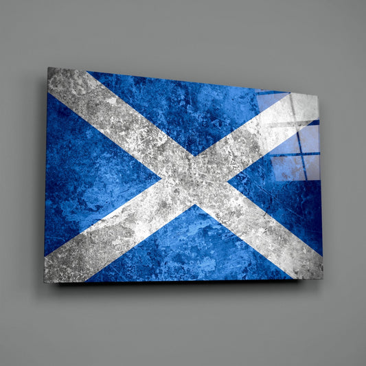 Angled three-quarter view of a glass wall art panel displaying the Scottish saltire flag with weathered concrete texture on blue background.