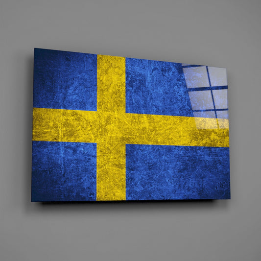 Swedish flag glass wall art panel displayed at an angle, showing blue and yellow cross design with textured surface and shadow.
