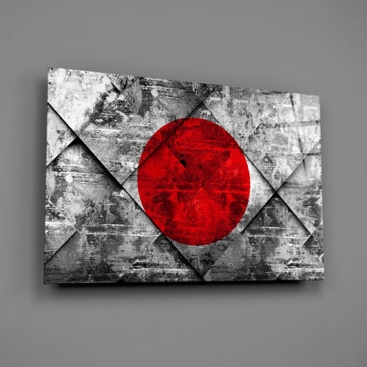 Angled view of glass wall art displaying Japan's flag with red circle on geometric gray concrete pattern background.