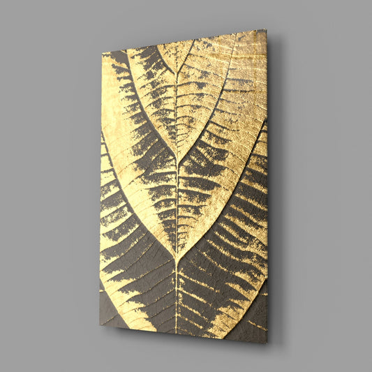 Angled perspective of rectangular glass wall art displaying gold foil leaf vein patterns on charcoal background.