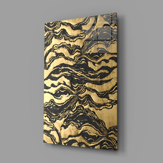 Black and gold marbled glass wall art panel displayed at an angle against a gray background, showing rippled wave pattern.