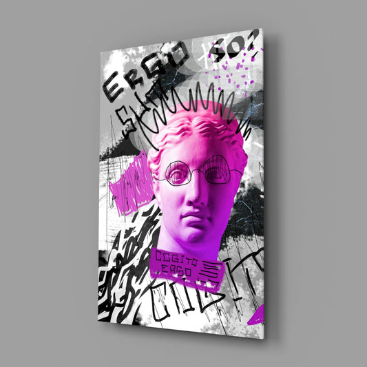 Angled side view of a glass wall art panel featuring a neon pink classical bust with round glasses and black graffiti elements on a gray background.