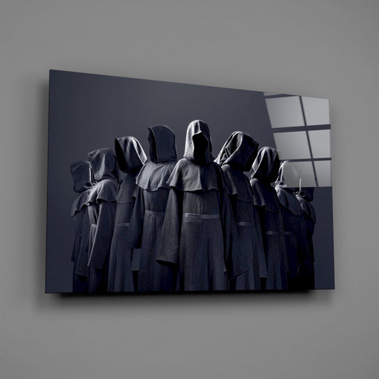 Glass wall art displaying seven hooded figures in dark robes against a dark background with geometric window pattern detail.