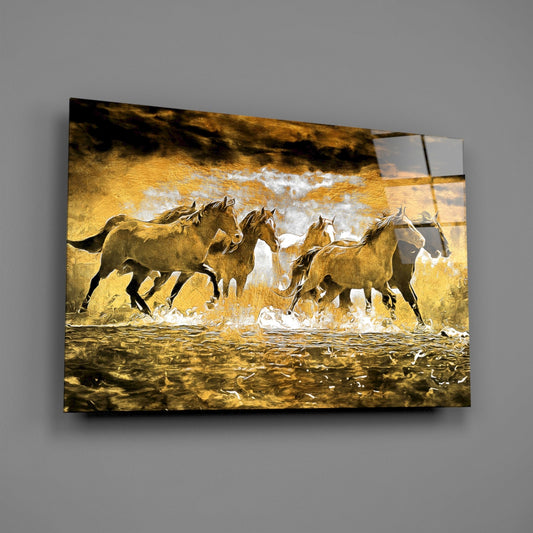 Golden glass wall art displaying a herd of horses galloping through water with white spray, mounted at an angle on gray wall.