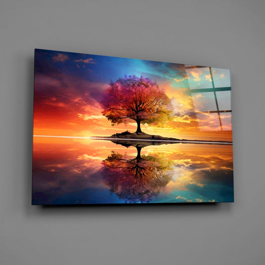 Colorful glass wall art panel displaying a tree with mirror reflection against a vibrant sunset sky in warm orange and cool blue tones.