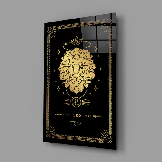 Angled view of black glass wall art with gold Leo zodiac lion design, decorative border, and celestial symbols on dark background.