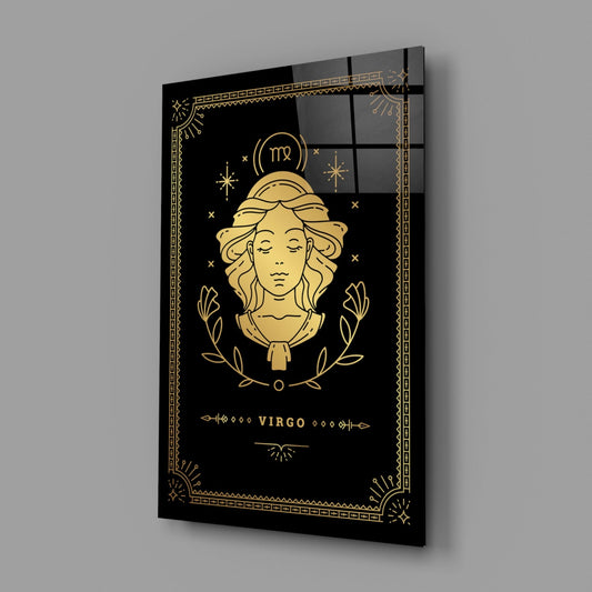 Angled perspective of black glass Virgo zodiac wall art with gold line illustration of female face, laurel wreath, and decorative border.