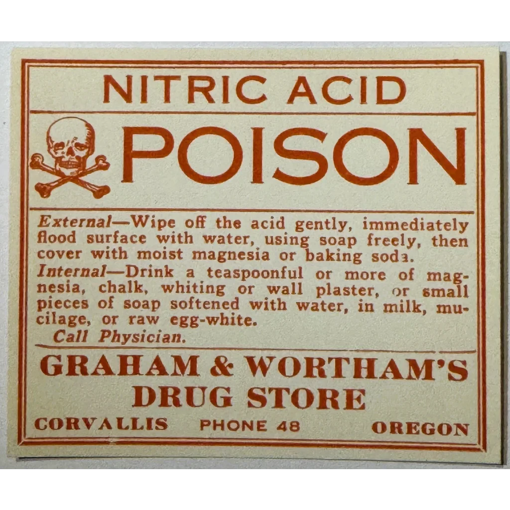 Antique 1910s nitric acid poison label from Graham and Wortham's Drug Store in Corvallis, Oregon, featuring a skull and crossbones warning.