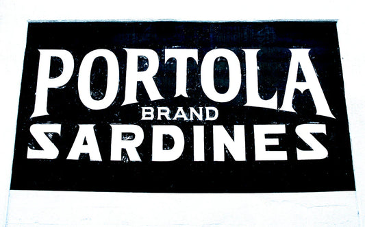 Vintage black and white Portola Brand Sardines sign showcasing classic vintage brand mascots